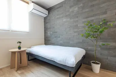 a bed in a room with a brick wall at \u30d9\u30eb\u30d3\u30fc\u4eac\u5cf6 Belle Vie Kyoujima in Tokyo