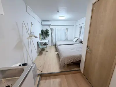 a bedroom with a bed and a desk and a door at \u5e83\u6587\u6771\u6c60\u888b302 in Tokyo