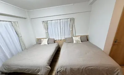two beds in a room with two windows at \u5e83\u6587\u6771\u6c60\u888b302 in Tokyo