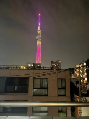 a tower is lit up in pink at night at \u30d5\u30a1\u30fc\u30b9\u30c8\u30cf\u30a4\u30c4401 in Tokyo