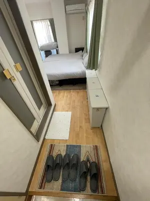 a hallway with a room with a bed and a pair of shoes at \u30d5\u30a1\u30fc\u30b9\u30c8\u30cf\u30a4\u30c4401 in Tokyo
