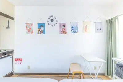 a bedroom with a white wall with pictures on it at \u30d5\u30a1\u30fc\u30b9\u30c8\u30cf\u30a4\u30c4401 in Tokyo