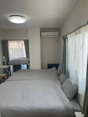 a bed in a small room with a window at \u30d5\u30a1\u30fc\u30b9\u30c8\u30cf\u30a4\u30c4401 in Tokyo