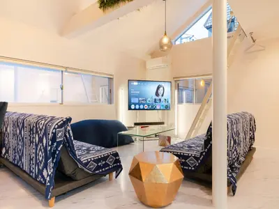 a living room with two chairs and a tv at Meguro Sta 2 min , Shirokanedai Sta 2 min ,Family & Group Friendly,Switch,Wi-Fi in Tokyo