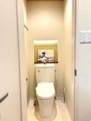 a bathroom with a toilet with a painting on the wall at Designers apartment Shibuya Shinjuku area in Tokyo