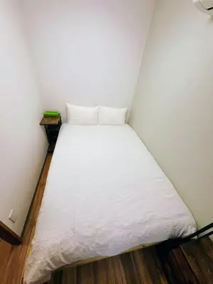 a bed in a small room with a white mattress at NYCottageAnnex2\u5ba41\u30ea\u30d3\u30f3\u30b01\u30b7\u30e3\u30ef\u30fc1\u30c8\u30a4\u30ec in Tokyo