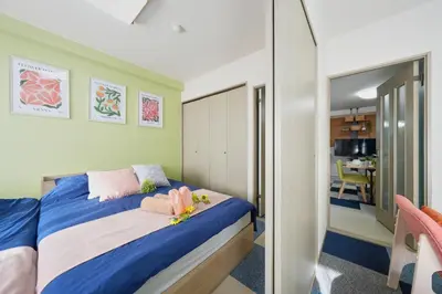 a bedroom with a bed with pink and blue sheets at Shamrock Aoto 202 Cozy Tokyo Stay Near Station Airport Disney Access in Tokyo
