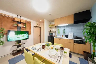 a kitchen with a dining room table with yellow chairs at Shamrock Aoto 202 Cozy Tokyo Stay Near Station Airport Disney Access in Tokyo