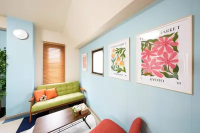 a living room with a green couch and flowers on the wall at Shamrock Aoto 301 Cozy Tokyo Stay Near Station Airport Disney Access in Tokyo