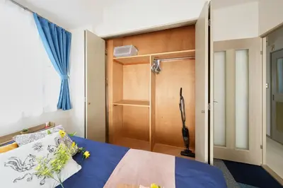 a bedroom with a bed and a wooden door at Shamrock Aoto 301 Cozy Tokyo Stay Near Station Airport Disney Access in Tokyo
