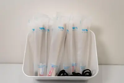 a container filled with white shower curtains and scissors at Wa Hostel in Tokyo