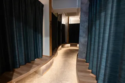 a room with blue curtains and a long hallway with wooden floors at Wa Hostel in Tokyo