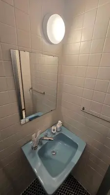 a bathroom with a blue sink and a mirror at Tourist Hotel New Aoki \u89b3\u5149\u30db\u30c6\u30eb \u30cb\u30e5\u30fc\u9752\u6728 in Tokyo