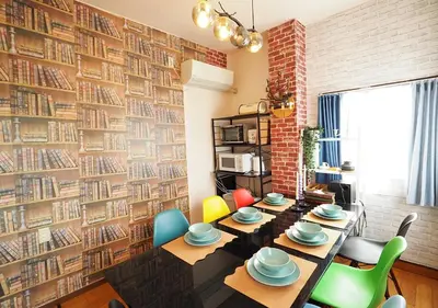 a dining room with a brick wall with books at 301 Koiwa Grand House in Tokyo