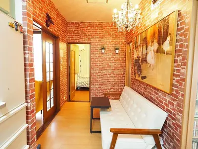 a living room with a brick wall and a white couch at 301 Koiwa Grand House in Tokyo