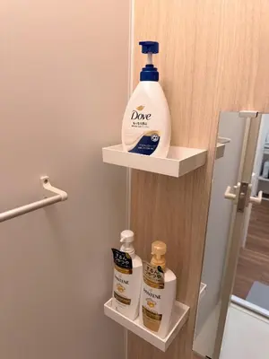 a bathroom with a shelf with a bottle of cleaner at C&H hotel3F in Tokyo