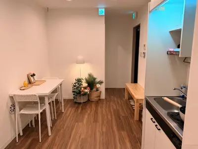 a kitchen and dining room with a white table at C&H hotel3F in Tokyo