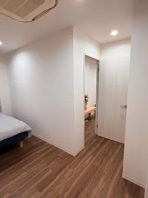 a bedroom with white walls and a bed and a table at C&H hotel3F in Tokyo