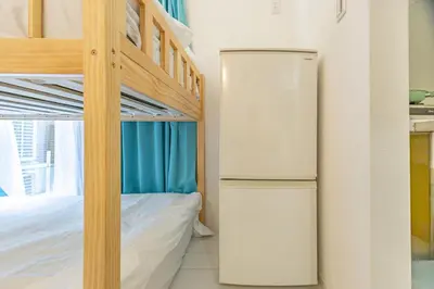 a bedroom with two bunk beds and a refrigerator at Otsuka 7 mins one stop to Ikebukuro mansion with garden in Tokyo