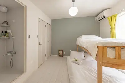 a bedroom with two bunk beds and a bathroom at Otsuka 7 mins one stop to Ikebukuro mansion with garden in Tokyo