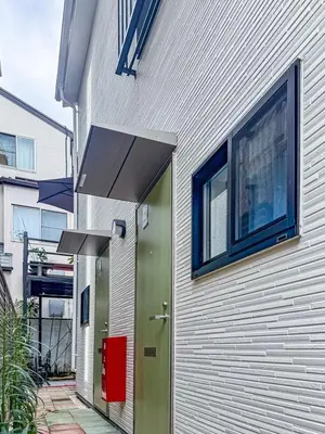 a white building with a green door and windows at Otsuka 7 mins one stop to Ikebukuro mansion with garden in Tokyo