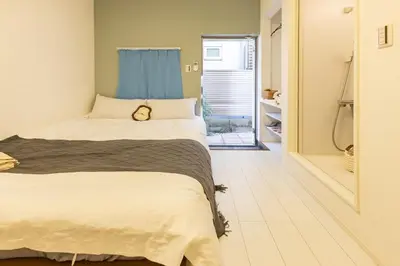 a bedroom with a large bed and a bathroom at Otsuka 7 mins one stop to Ikebukuro mansion with garden in Tokyo