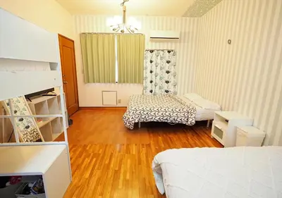 a bedroom with two beds and wooden floors at Koiwa Guesthouse Tokyo in Tokyo