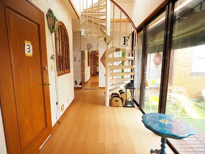 a hallway with a staircase and a stool in a room at Koiwa Guesthouse Tokyo in Tokyo