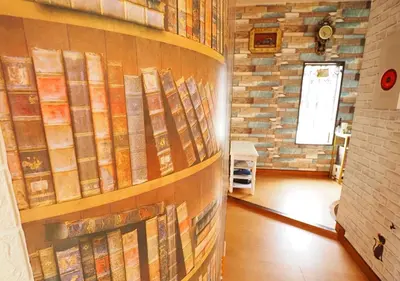 a room with a bunch of books on a wall at Koiwa Guesthouse Tokyo in Tokyo