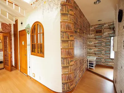 a room with a wall filled with books at Koiwa Guesthouse Tokyo in Tokyo