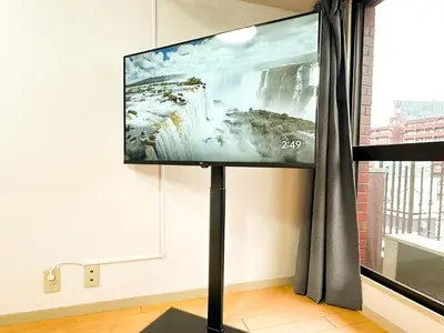 a flat screen tv on a stand in a room at Shinjuku Kabukicho Cozy Bed&Living in Tokyo