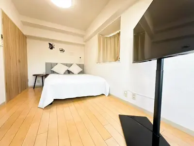 a bedroom with a bed and a flat screen tv at Shinjuku Kabukicho Cozy Bed&Living in Tokyo