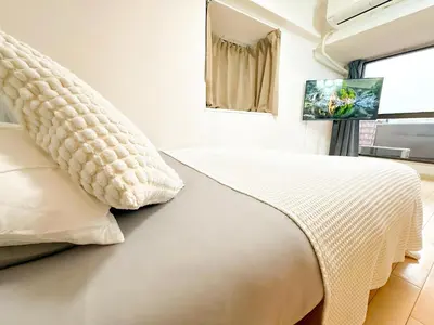 a bedroom with a bed with a pillow and a window at Shinjuku Kabukicho Cozy Bed&Living in Tokyo