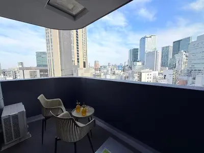 a balcony with a table and chairs and a view of a city at Cozy APT Stay in Center Tokyo -SHIBUYA in Tokyo