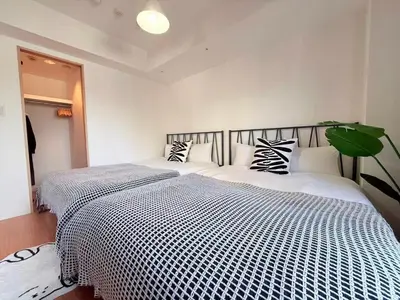 a bedroom with a large bed with black and white sheets at Cozy APT Stay in Center Tokyo -SHIBUYA in Tokyo