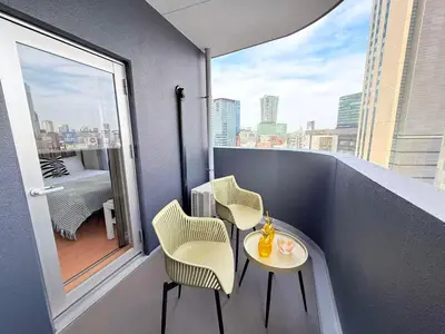a balcony with two chairs and a table and a window at Cozy APT Stay in Center Tokyo -SHIBUYA in Tokyo