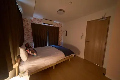 a bedroom with a bed and a window and a door at Clavis Asakusa Skytree in Tokyo