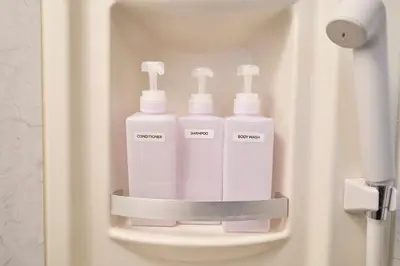 a bathroom with three white bottles in a holder at Clavis Asakusa Skytree in Tokyo