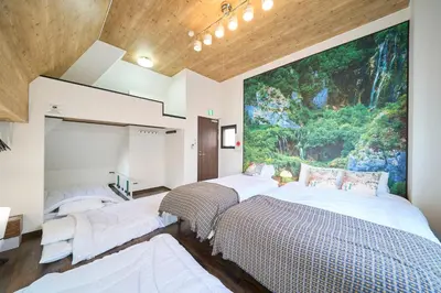 two beds in a room with a painting on the wall at Clavis Asakusa Skytree in Tokyo