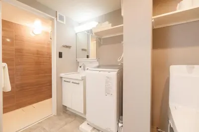 a bathroom with a sink and a washer and dryer at TORA HOTEL Kamata in Tokyo