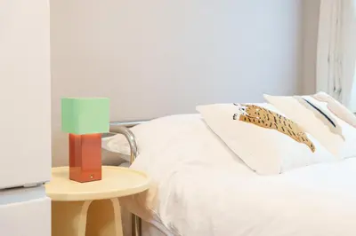 a bedroom with a bed and a table with a lamp at TORA HOTEL Kamata in Tokyo
