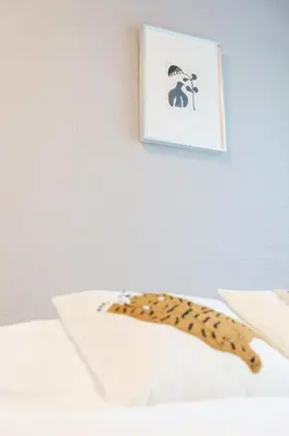 a leopard print blanket on a bed with a picture at TORA HOTEL Kamata in Tokyo
