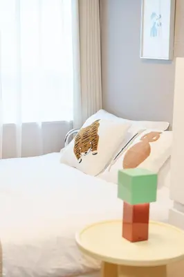 a bedroom with a bed with a table next to it at TORA HOTEL Kamata in Tokyo