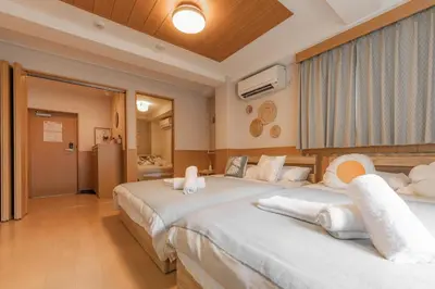 a bedroom with two beds with white sheets at Ginza401 Tsukiji 3mins,Tsukiji Market in Tokyo
