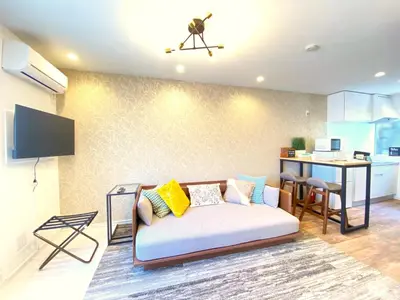 a living room with a couch and a kitchen at Hale Akasaka - The House in Tokyo