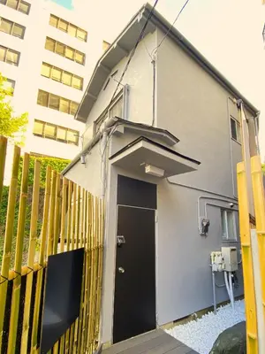 a building with a black door next to a fence at Hale Akasaka - The House in Tokyo