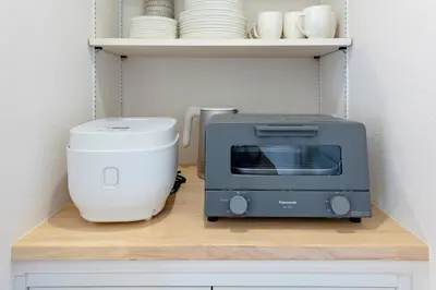 a microwave and a toaster sitting on a shelf at Hours House\u9ad8\u78021 in Tokyo