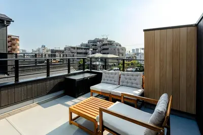 a balcony with two chairs and a table at Hours House\u9ad8\u78021 in Tokyo