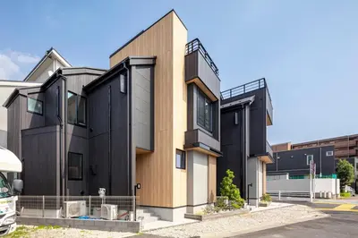 a black and wooden house in a parking lot at Hours House\u9ad8\u78021 in Tokyo