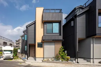 a modern house with a black and wooden facade at Hours House\u9ad8\u78021 in Tokyo